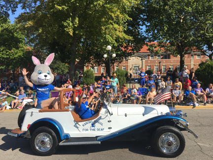 Gary Cross and Jackrabbit costume are driving the KSD Antique car and is waving at the people.
