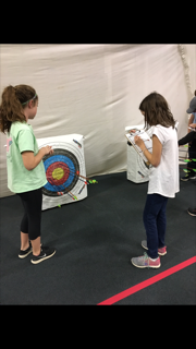 Two girls checking target to see where the arrow landed